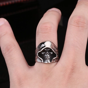 Macro detail of men's vintage stainless steel grim reaper skull ring with aged silver finish