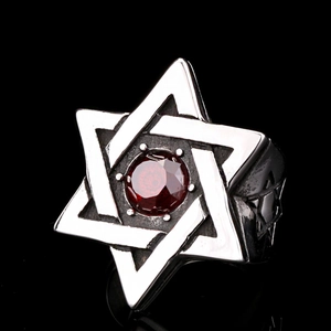 Macro view of silver star of David ring with a round red zircon and vintage patterns