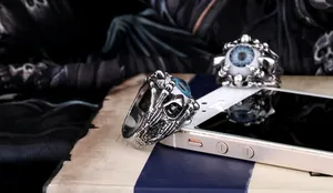 Detailed close-up of punk-style blue evil eye ring with silver eagle claw design