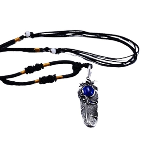 Vintage silver feather pendant necklace featuring a blue sapphire gem on a black woven cord