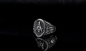 Macro shot of vintage stainless steel Masonic ring with square and compass G symbol