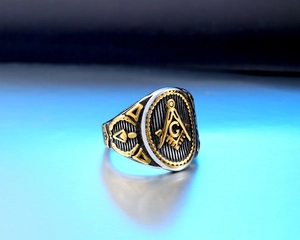 Macro shot of silver and gold stainless steel Freemasonry ring with detailed engravings