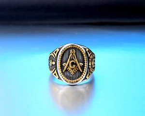 Close-up of vintage bicolor stainless steel ring with Freemasonry symbol and G engraving