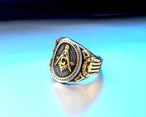 Macro shot of vintage Freemason stainless steel ring showing compass and square details
