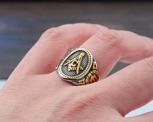 Close-up of a silver stainless steel Masonic ring with gold compass and square emblem