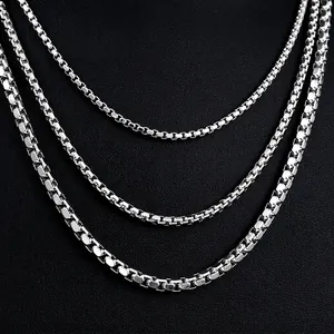 Polished silver stainless steel box chains in three widths on black leather background