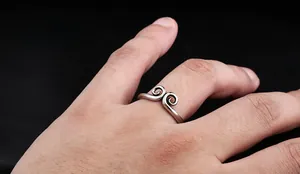 Détail d'une bague Sun Wukong en argent vintage avec motif de nuages sur le doigt d'un homme