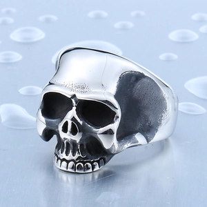 Polished titanium steel skull ring for men with vintage finish on a blue metallic background