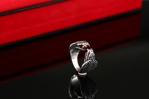 Detailed close-up of a double-headed snake ring with red gems and silver scales