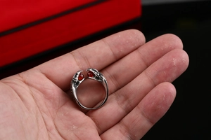 Detail of gothic stainless steel dragon claw ring with vibrant red synthetic stones