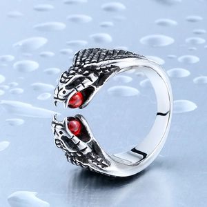Vintage stainless steel double snake head ring with red beads on blue background