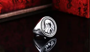 Détail macro d'une bague vintage en acier avec motif fantôme et gravure Infidels latérale