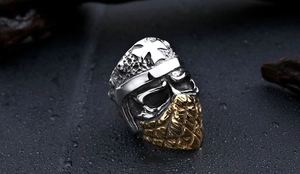 Macro view of vintage silver skull helmet ring with gold cross and hammered texture