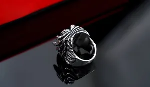 Macro detail of men's stainless steel wing ring with intricate vintage feather carvings