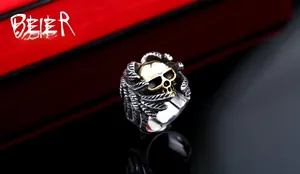 Detailed close-up of a gothic skull ring with golden face and silver steel wings