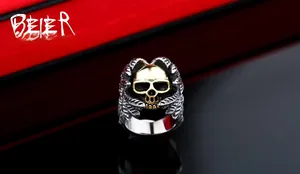 Macro detail of gothic punk skull ring featuring vintage gold skull and silver feather wings