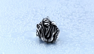 Détail macro d'une bague tête de bouledogue avec finition vintage sur fond d'eau