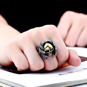 Vintage stainless steel skull ring with golden wings shown on a lifestyle magazine