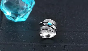 Macro detail of vintage silver feather ring with turquoise inlay and oxidized texture