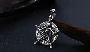 Vue détaillée du pendentif gothique avec crâne et pentagramme sur fond de bois