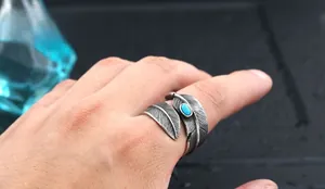 Macro detail of a vintage feather ring in oxidized steel with an oval turquoise gemstone