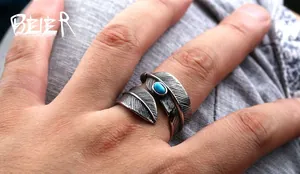Macro shot of vintage silver feather ring featuring a turquoise stone and textured details