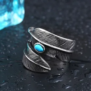 Vintage titanium steel feather open ring with turquoise inlay on dark textured surface