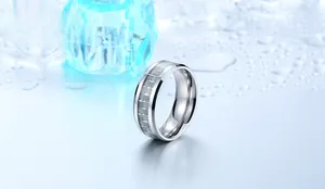 Detailed view of silver titanium steel ring with grey grid inlay on blue ice background