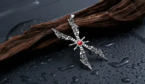 Detail of gothic steel sword pendant with engraved filigree and red zircon stone