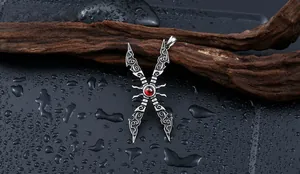 Macro shot of a vintage titanium steel pendant featuring red zircon inlay and ornate engraving