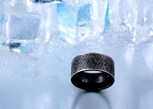 Macro detail of men's titanium steel ring with embossed ethnic dragon patterns on ice