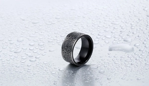 Detailed close-up of retro black titanium ring with silver beast totem engravings