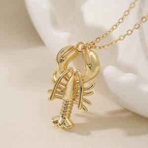 Collana con ciondolo a aragosta placcata oro con finitura lucida su vassoio bianco