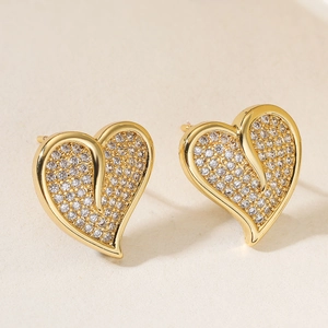 18K gold plated heart stud earrings with sparkling cubic zirconia on warm texture background