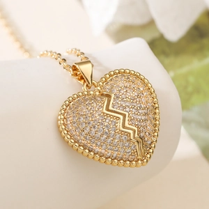 Collier avec pendentif cœur brisé plaqué or avec zircons étincelants et motif d'éclair