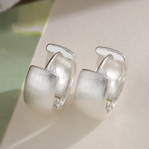 Minimalist brushed silver hoop earrings with matte texture and polished inner surface