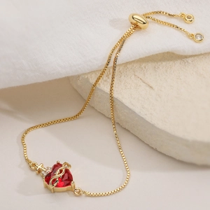 Bracelet ajustable doré avec cœur en zircon rouge et détails de petite couronne