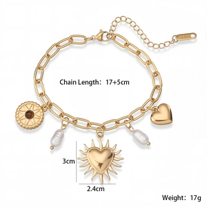 Détail des breloques cœur et perle en or 18 carats sur un bracelet à maillons