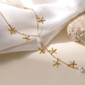Collier étoile de mer doré avec perles blanches sur fond de soie blanche élégante