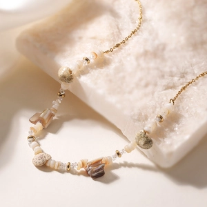 Collier bohème en acier doré avec coquillages naturels et perles blanches sur pierre