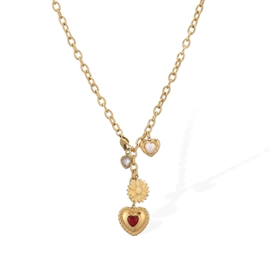 Vue détaillée du collier en acier doré avec pendentifs cœur rouge et tournesol