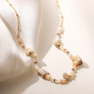 Collier élégant en acier inoxydable doré avec des coquillages naturels sur soie blanche