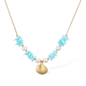 Golden sea shell necklace with blue stone accents and white pearls on a white background