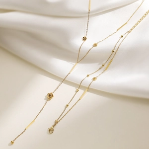 Minimalist gold rose pendant necklace with tassel bar and refined chain on silk