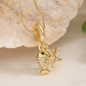 Collier plaqué or 18 carats avec pendentifs poisson et étoile de mer sur fond de pierre