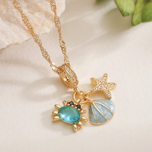 Détail du collier en or 18K avec pendentifs en forme de crabe, étoile de mer et coquillage