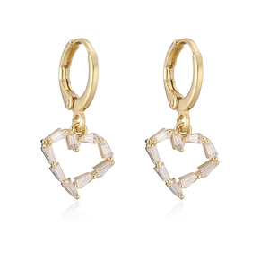 Detailed macro shot of heart-shaped gold-plated earrings with baguette-cut zircons