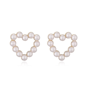 Macro shot of 18K gold plated heart-shaped pearl stud earrings with a glossy white finish
