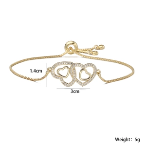 Detailed view of gold adjustable double heart bracelet with cubic zirconia inlay 3cm charm