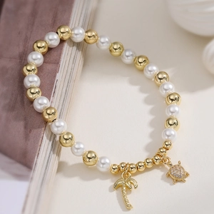 Beaded pearl bracelet with gold coconut tree and turtle charm pendants in beach style